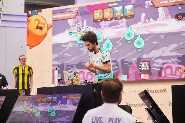 Un jugador festejando en su puesto del escenario, frente a la pantalla gigante